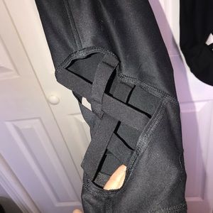 Black yoga pants with straps woven at the ankles